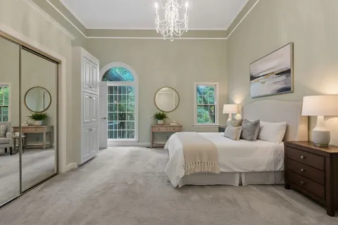 a bedroom with a bed mirror and a window