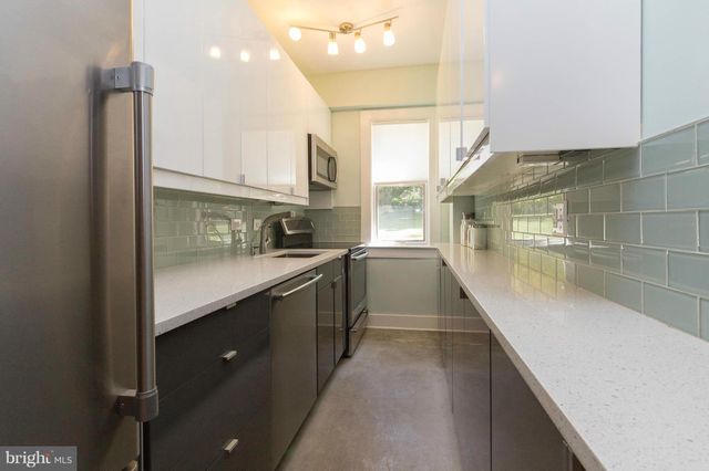 a kitchen with stainless steel appliances a sink a counter top space and cabinets
