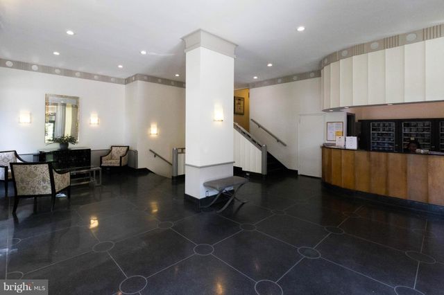 a living room with couches and kitchen view with wooden floor