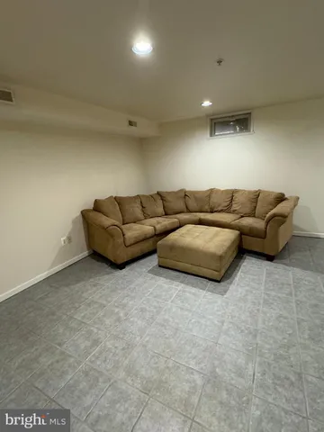 a living room with couches and kitchen view