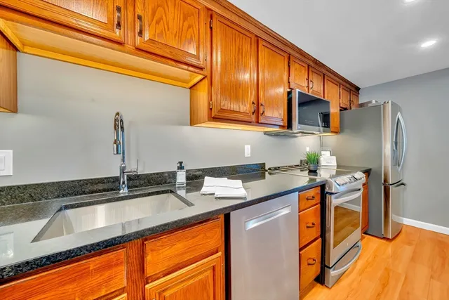 a kitchen with stainless steel appliances granite countertop a sink stove and refrigerator