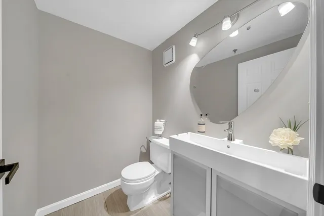 a bathroom with a sink mirror and toilet