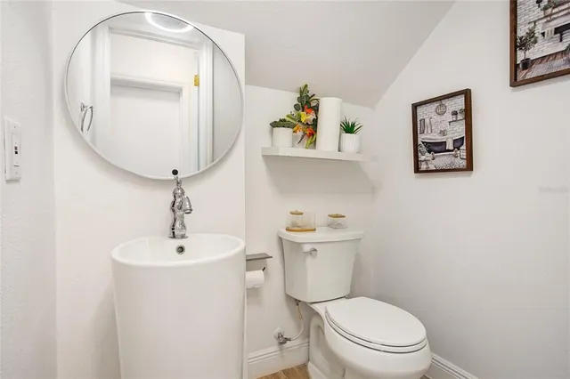 a bathroom with a toilet a sink and mirror