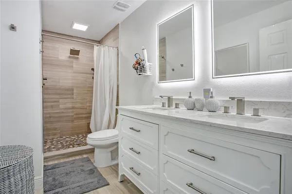 a bathroom with a granite countertop sink toilet and shower