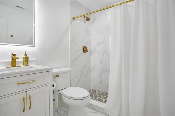 a bathroom with a sink a toilet and shower curtain