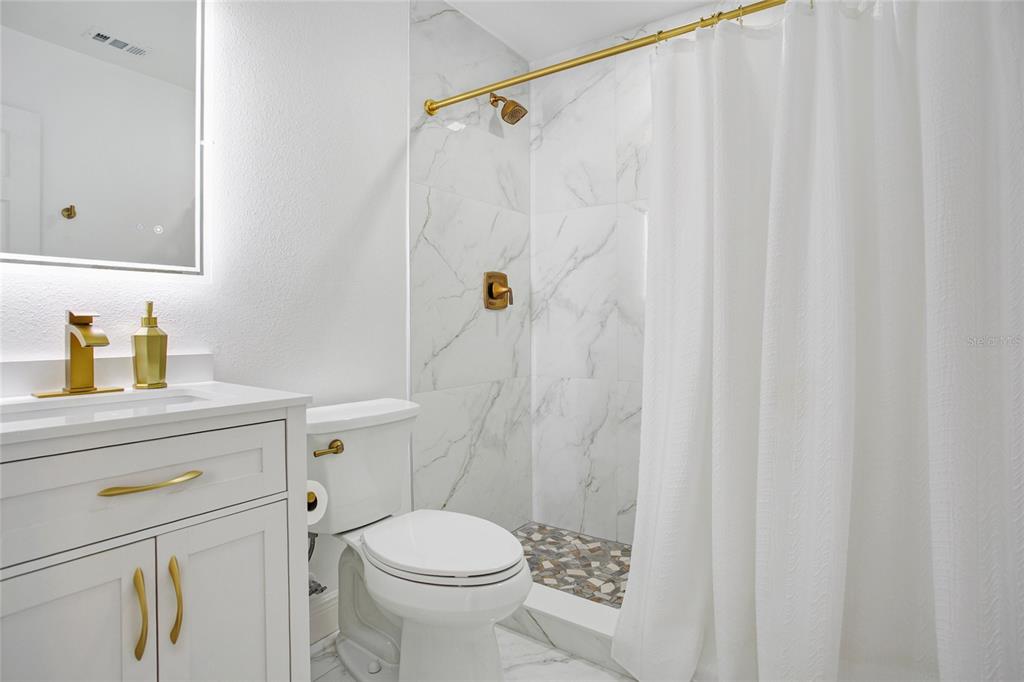 960 Strathmore Drive Orlando, FL 32806 - Photo 17 of 25 a bathroom with a sink a toilet and shower curtain