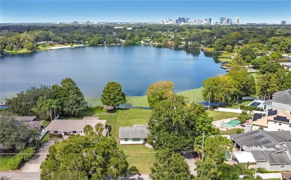 an aerial view of residential houses with outdoor space and lake view