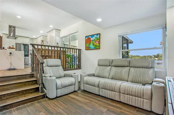 a living room with furniture and a night stand with wooden floor