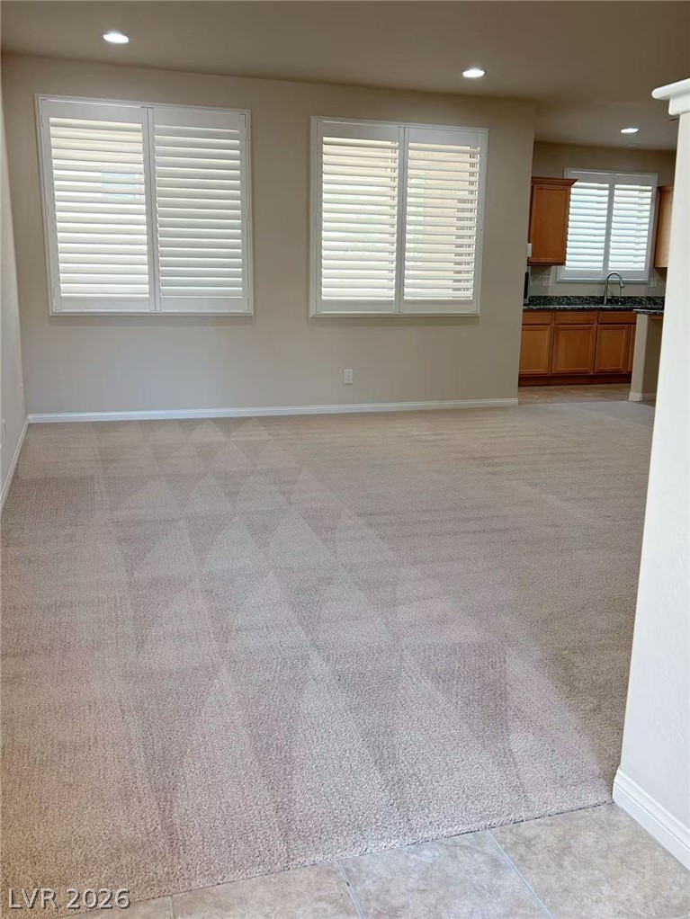 146 Tree Shot Court Las Vegas, NV 89113 - Photo 2 of 18 Bright windows with plantation shutters illuminate the comfortable carpeted living area.