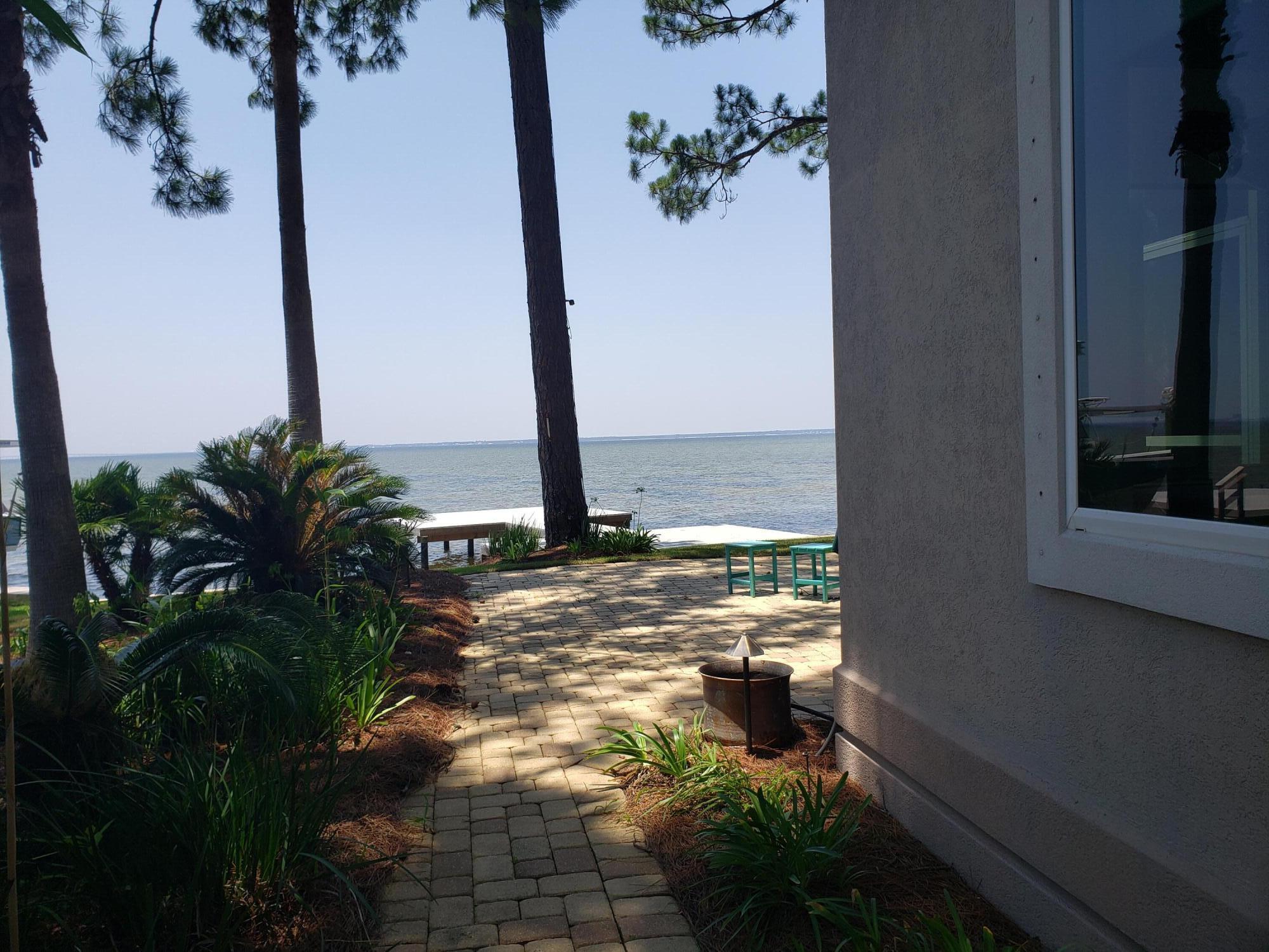 a view of a balcony with floor to ceiling window and potted plants