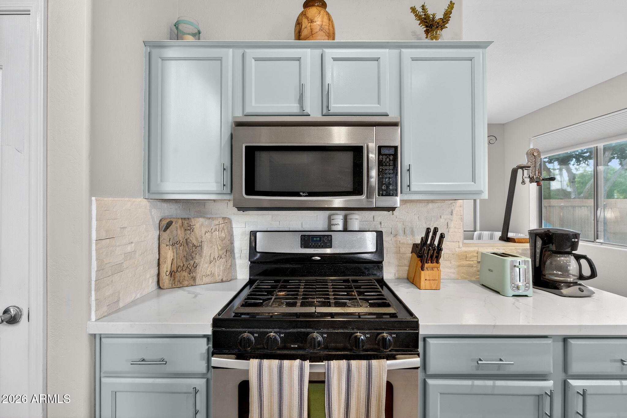 6280 South Sinova Court Gilbert, AZ 85298 - Photo 21 of 64 a kitchen with microwave a stove and cabinets