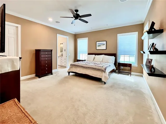 a spacious bedroom with a large bed and a chandelier
