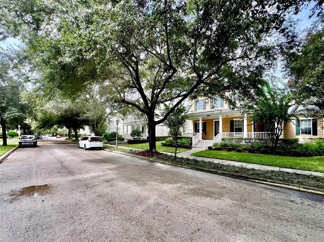 a view of a house with a big yard and large trees