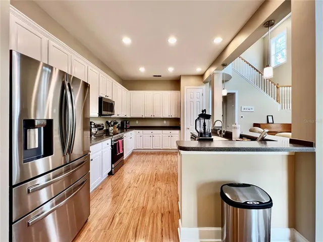 a kitchen with kitchen island a counter top space a sink stainless steel appliances and cabinets