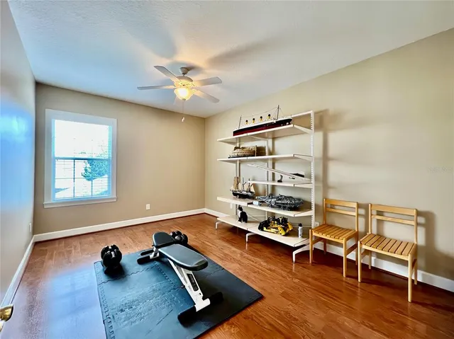 a room with gym equipment and wooden floor