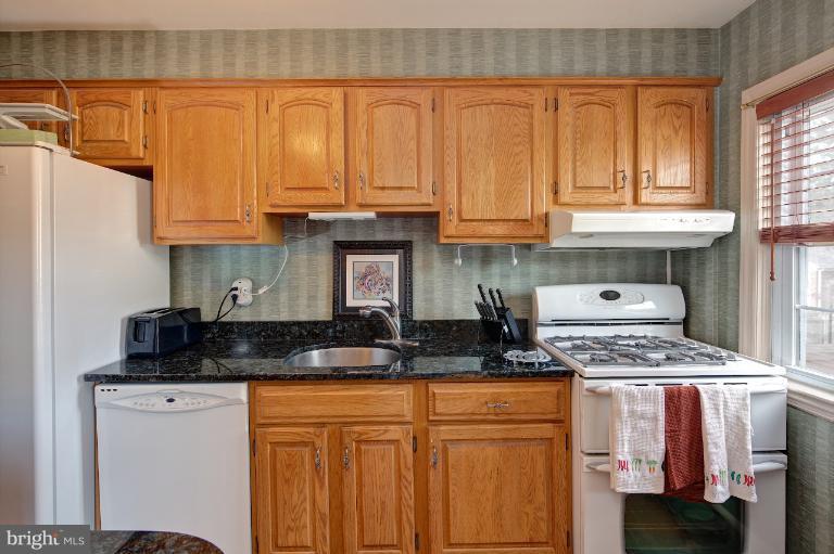 418 Overbrook Road Baltimore, MD 21212 - Photo 21 of 30 a kitchen with granite countertop a sink a stove and cabinets