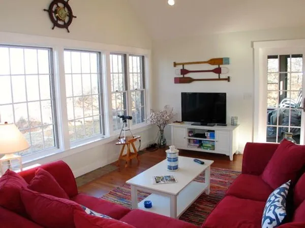 a living room with furniture a flat screen tv and a large window