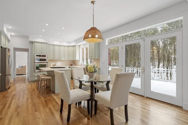 a dining room with furniture a chandelier and wooden floor