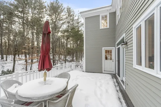 a patio with a table and chairs and wooden floor
