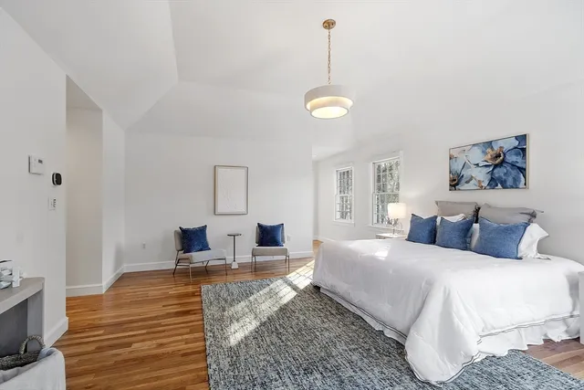 a bedroom with a bed and painting on the wall