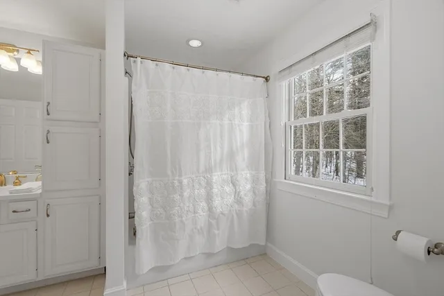 a bathroom with a shower curtain and a window