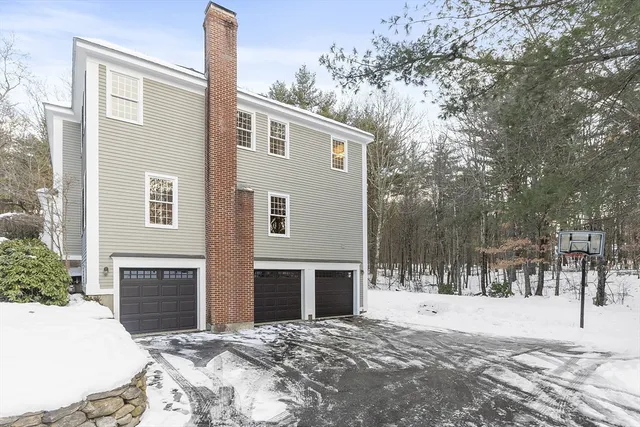 a front view of a house with a yard covered in snow