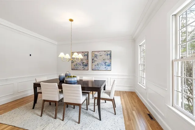 a dining room with furniture a chandelier and wooden floor