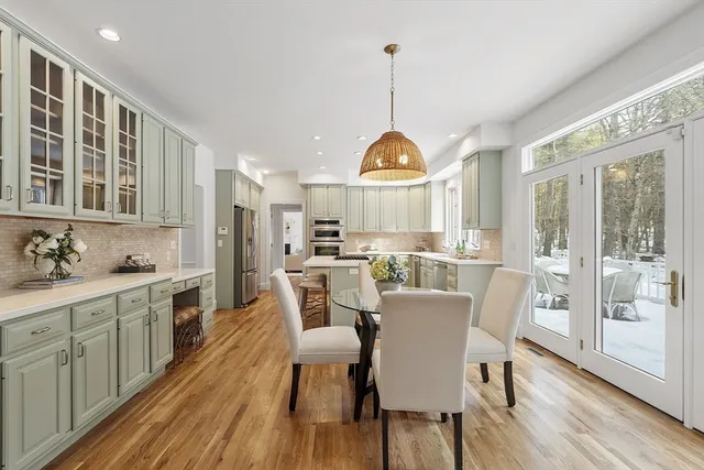 a view of a dining room and livingroom with furniture wooden floor a chandelier