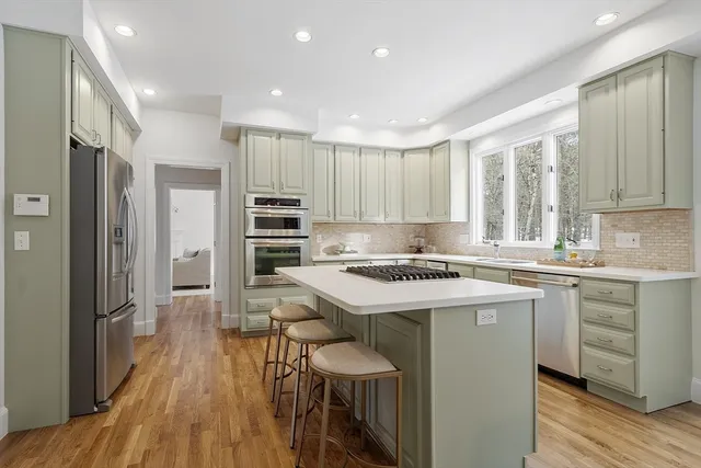 a kitchen with kitchen island a sink stove and refrigerator