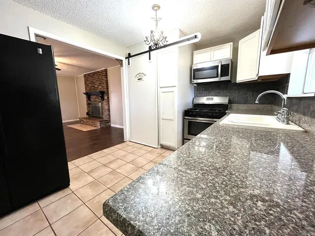 a kitchen with stainless steel appliances kitchen island granite countertop a refrigerator stove and sink