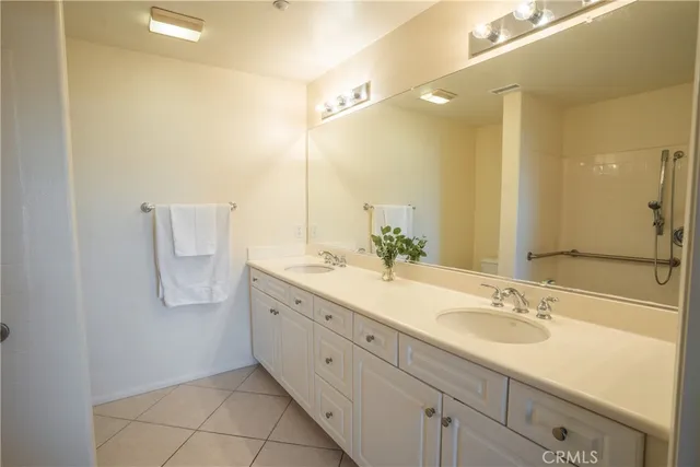 a bathroom with a granite countertop sink a mirror and a shower