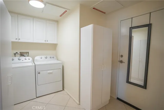 a utility room with cabinets washer and dryer