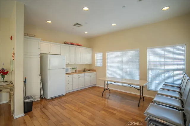 a kitchen with a refrigerator and white cabinets