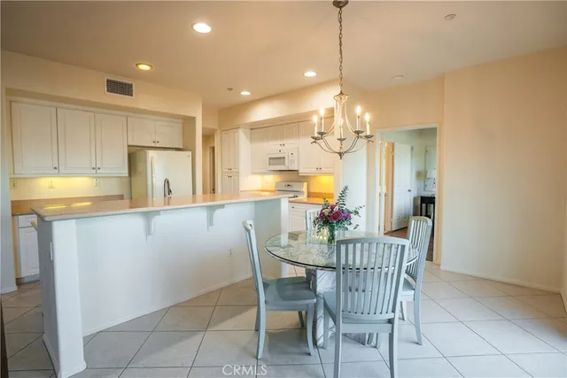 a kitchen with a dining table chairs and refrigerator