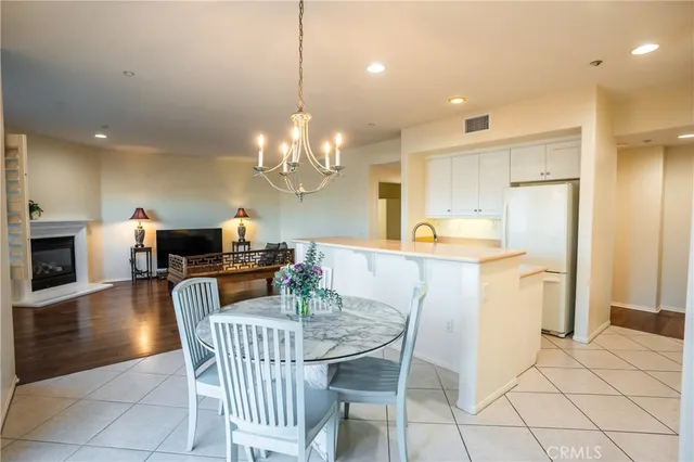 a dining room filled chandelier and kitchen view