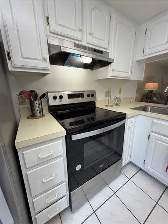 a kitchen with granite countertop white cabinets and stainless steel appliances