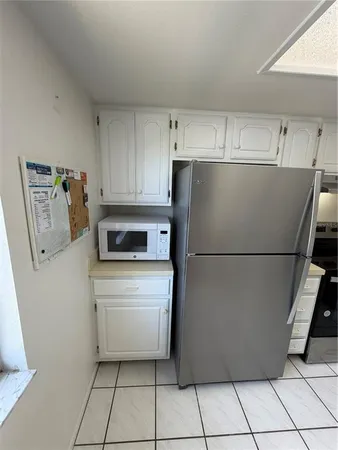 a white refrigerator freezer and a stove sitting inside of a kitchen