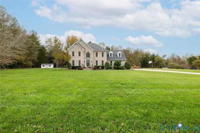 a view of a house with a big yard and large trees