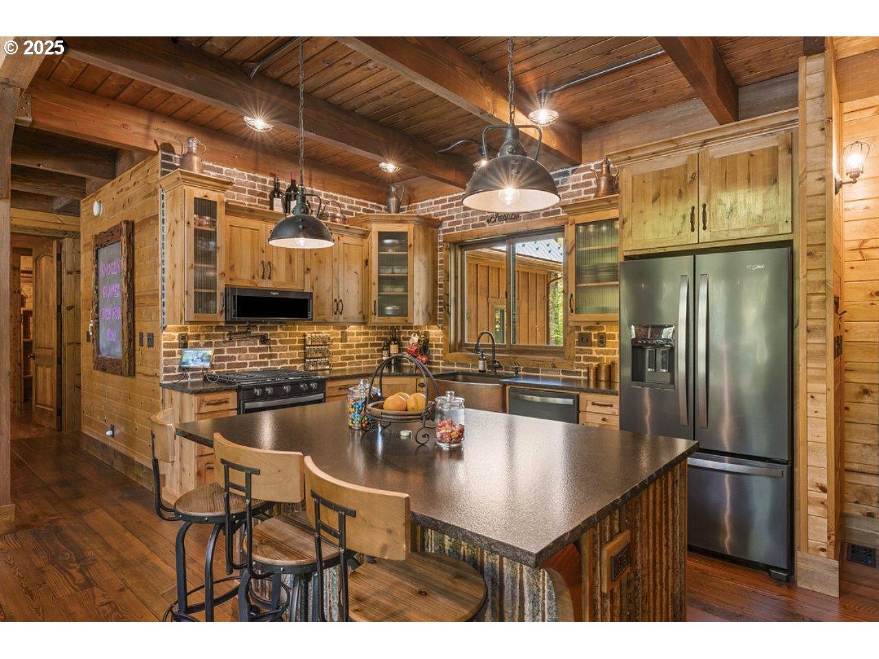55590 McKenzie River Drive Blue River, OR 97413 - Photo 12 of 45 a kitchen with stainless steel appliances kitchen island granite countertop a table chairs microwave and sink