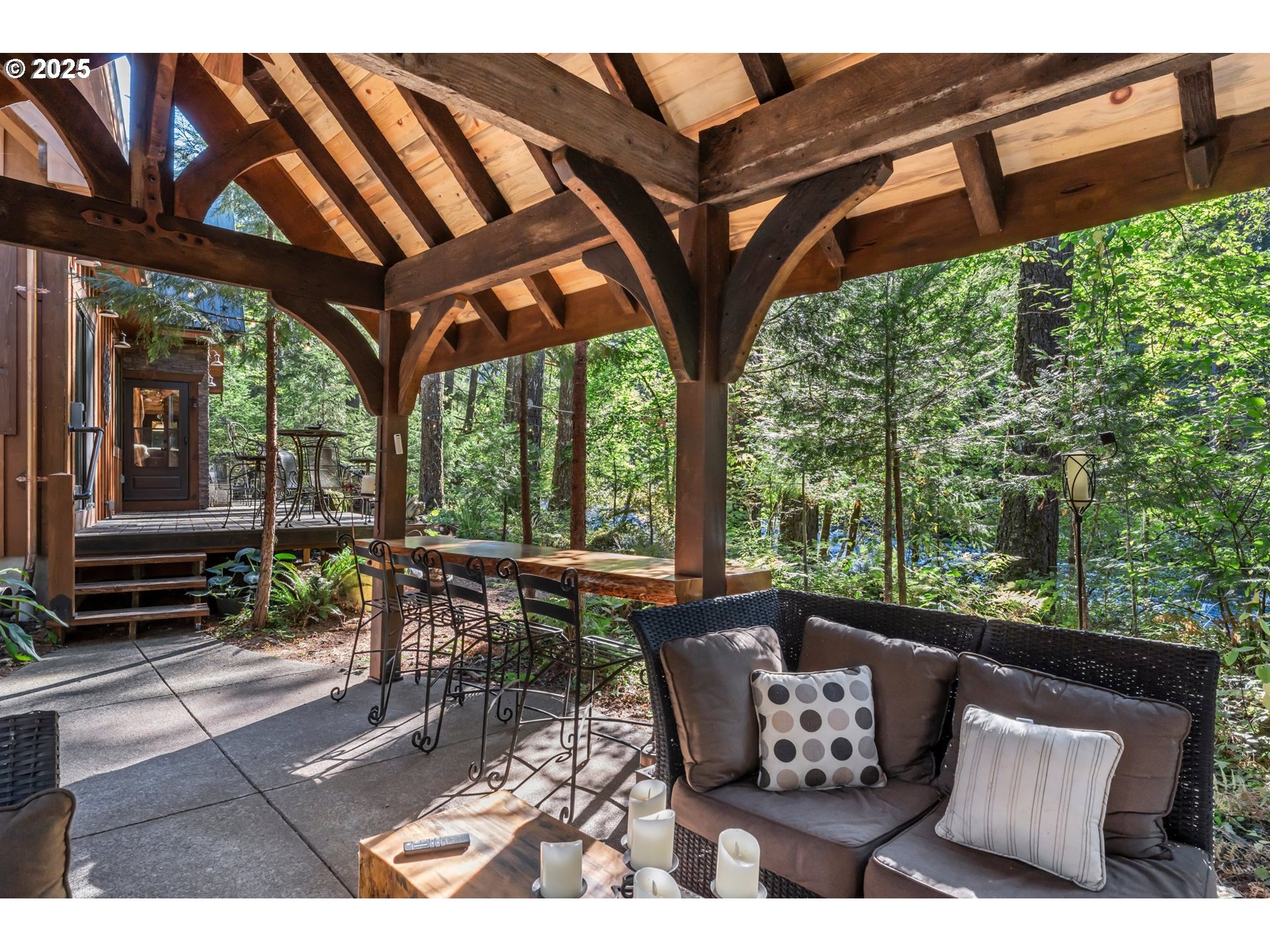 55590 McKenzie River Drive Blue River, OR 97413 - Photo 20 of 45 a view of a patio with table and chairs and floor to ceiling window next to a yard