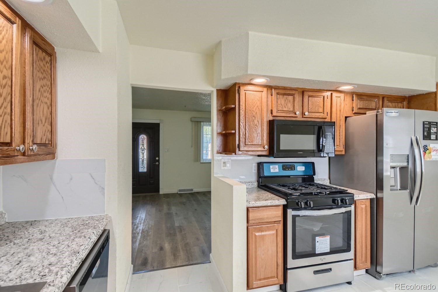 7480 Wolff Street Westminster, CO 80030 - Photo 5 of 16 a kitchen with stainless steel appliances granite countertop a refrigerator stove and sink