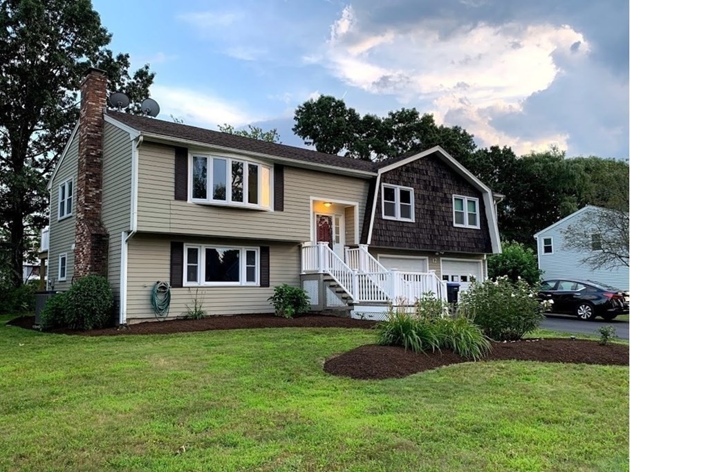 12 Burning Tree Road Natick, MA 01760 - Photo 1 of 34 a front view of a house with a garden and plants