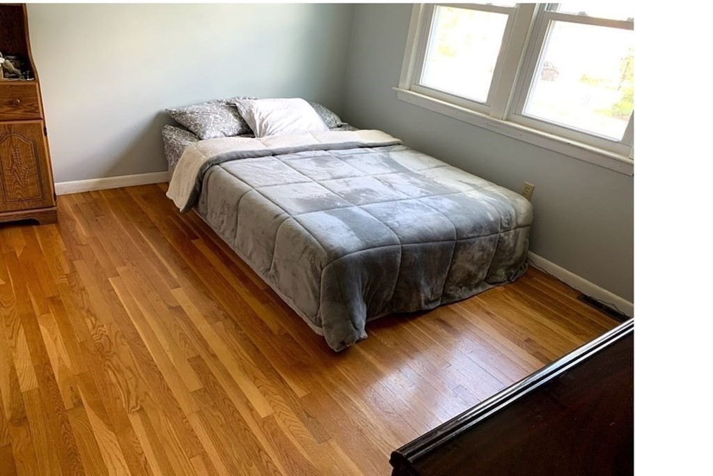 12 Burning Tree Road Natick, MA 01760 - Photo 22 of 34 a bedroom with a bed and wooden floor