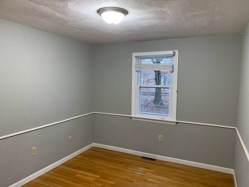 12 Burning Tree Road Natick, MA 01760 - Photo 23 of 34 a view of an empty room with wooden floor and a window