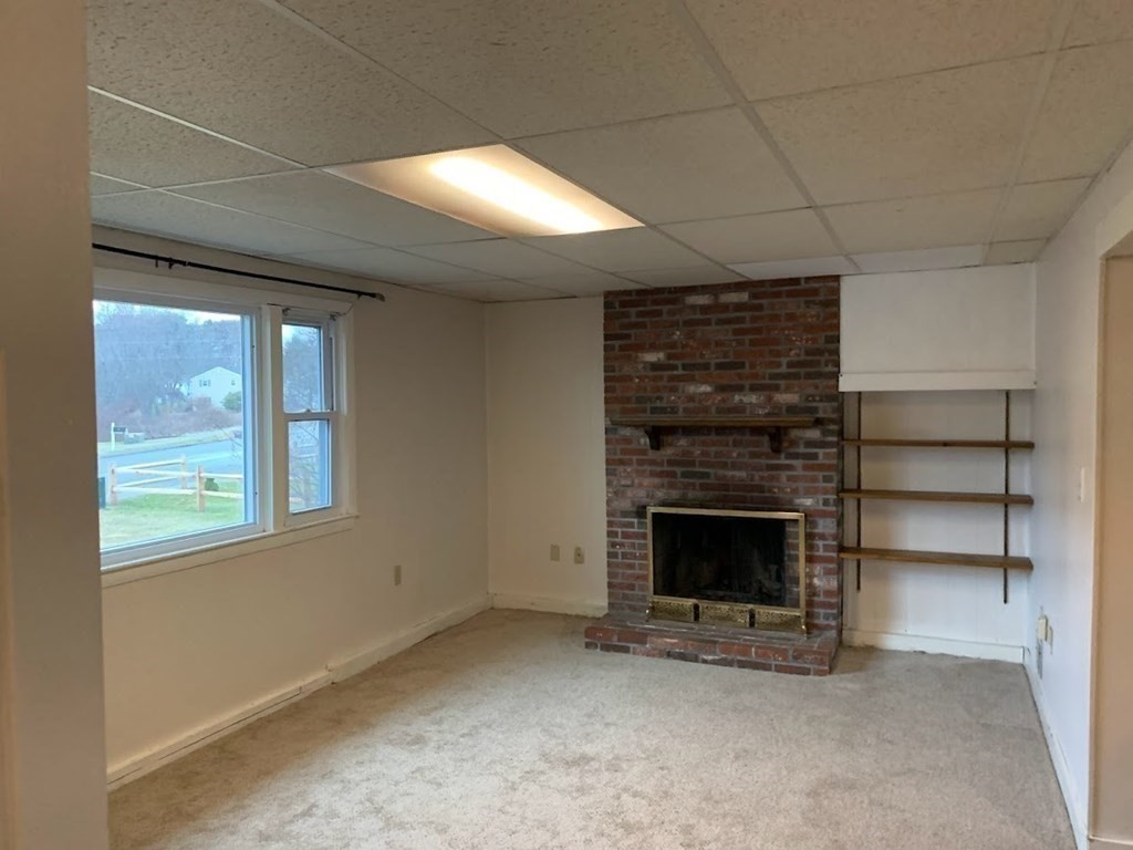 12 Burning Tree Road Natick, MA 01760 - Photo 25 of 34 a view of an empty room with a fireplace and a window