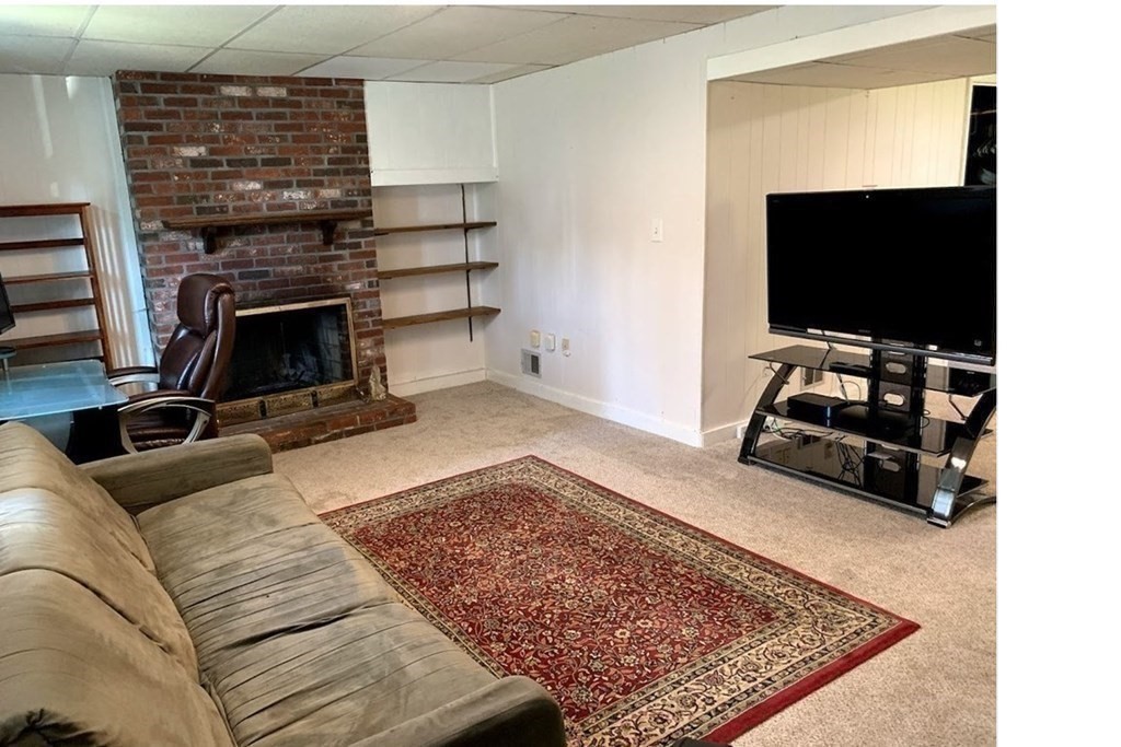 12 Burning Tree Road Natick, MA 01760 - Photo 26 of 34 a living room with furniture and a flat screen tv