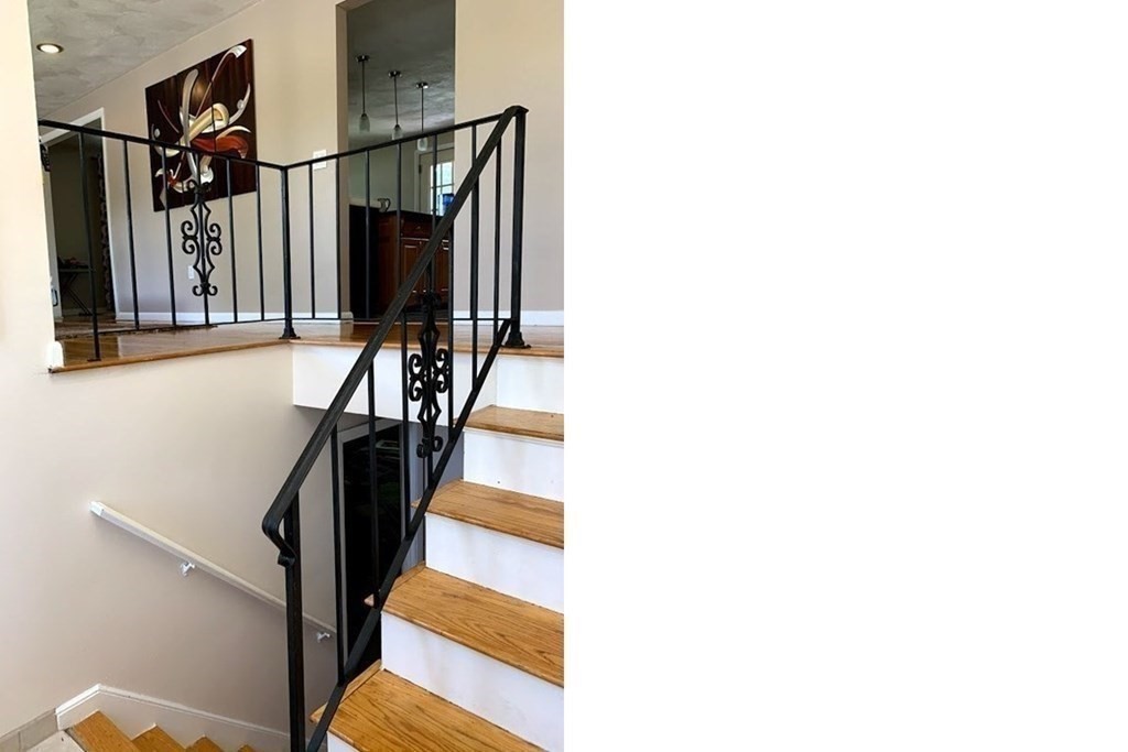 12 Burning Tree Road Natick, MA 01760 - Photo 10 of 34 a view of staircase with lots of frames on wall and a window