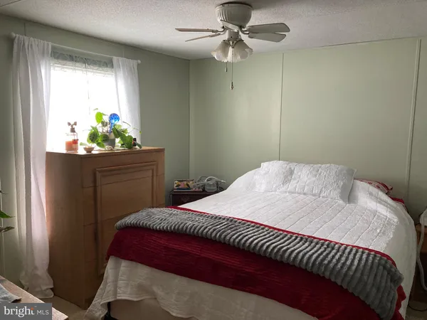 a bedroom with a bed and a potted plant