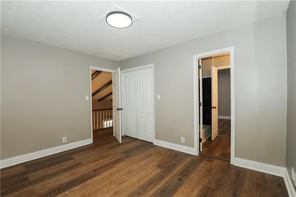 an empty room with wooden floor and closet