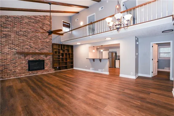 a view of empty room with wooden floor and fireplace